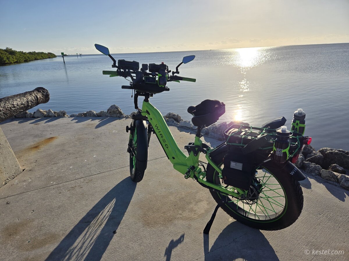 Electric bike parked at a waterfront at sunrise