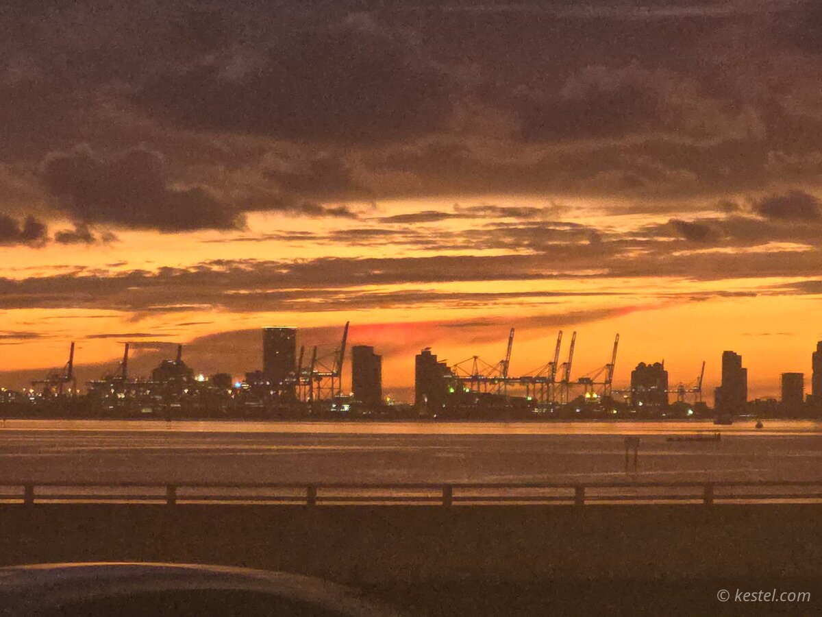 Miami port skyline silhouetted against a deep orange sunset