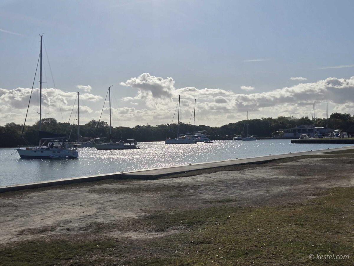 Sailboats moored at a marina under cloudy skies