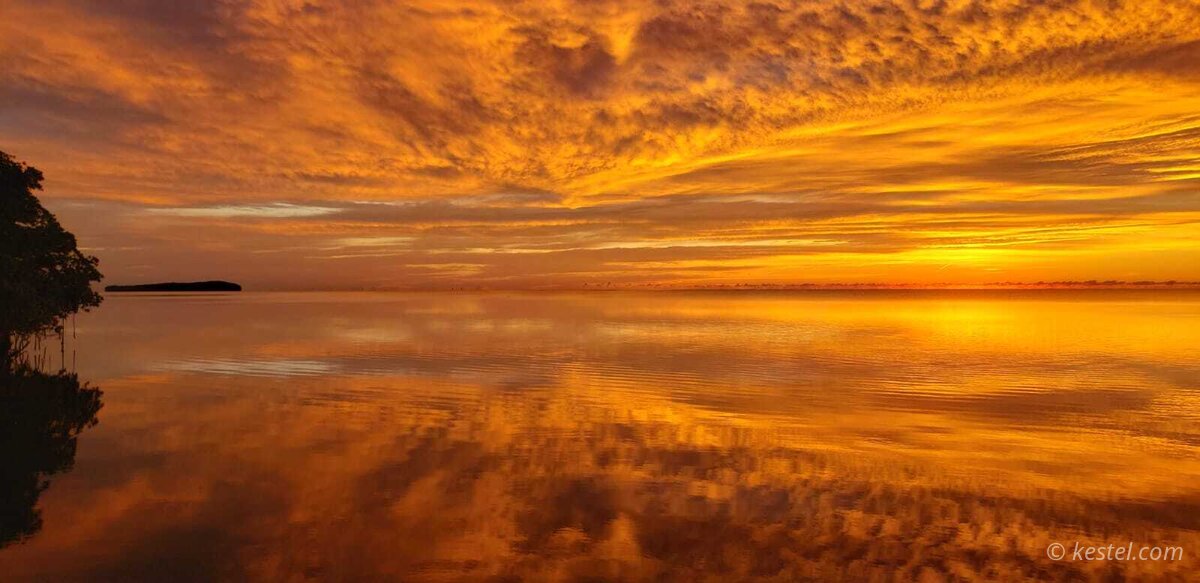 Mirror-calm bay at sunrise