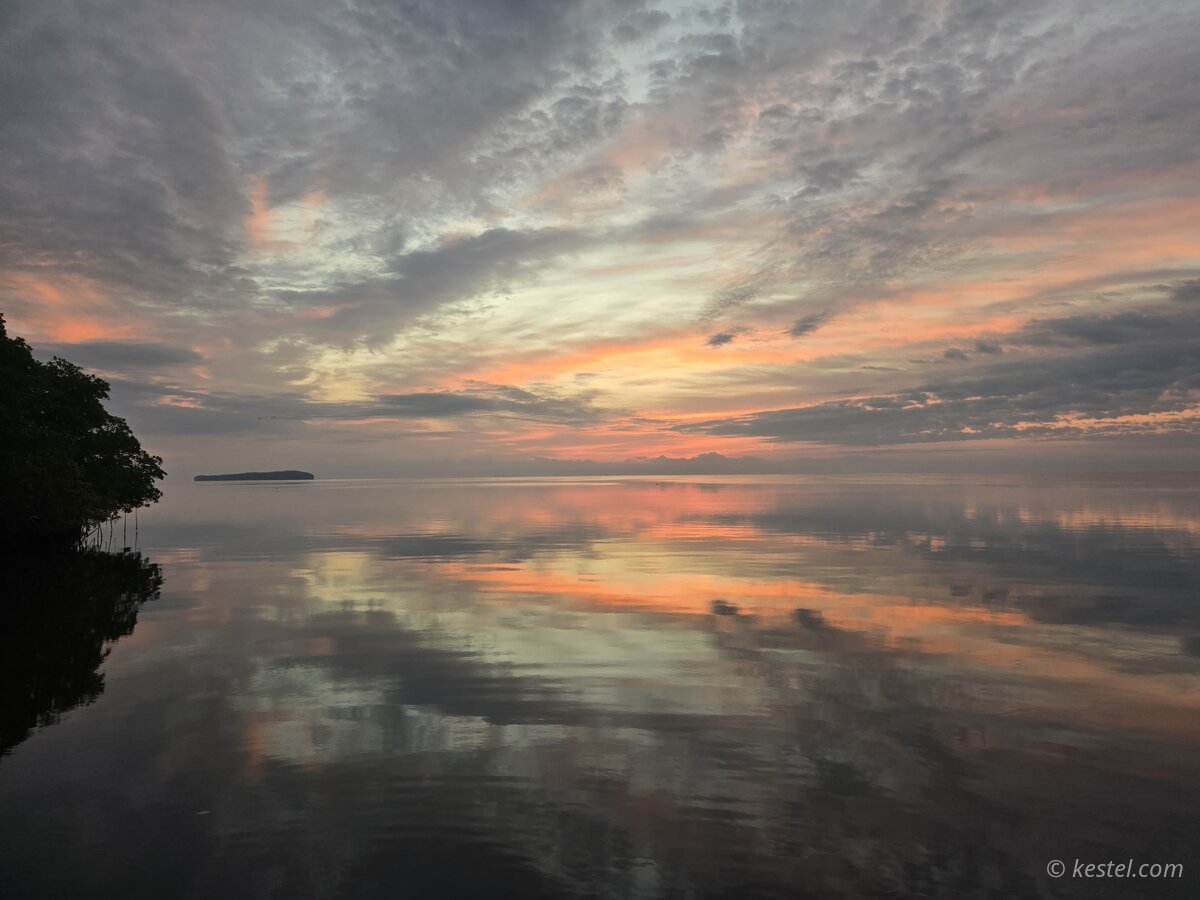 Soft pastel sunrise colors reflected in still bay
