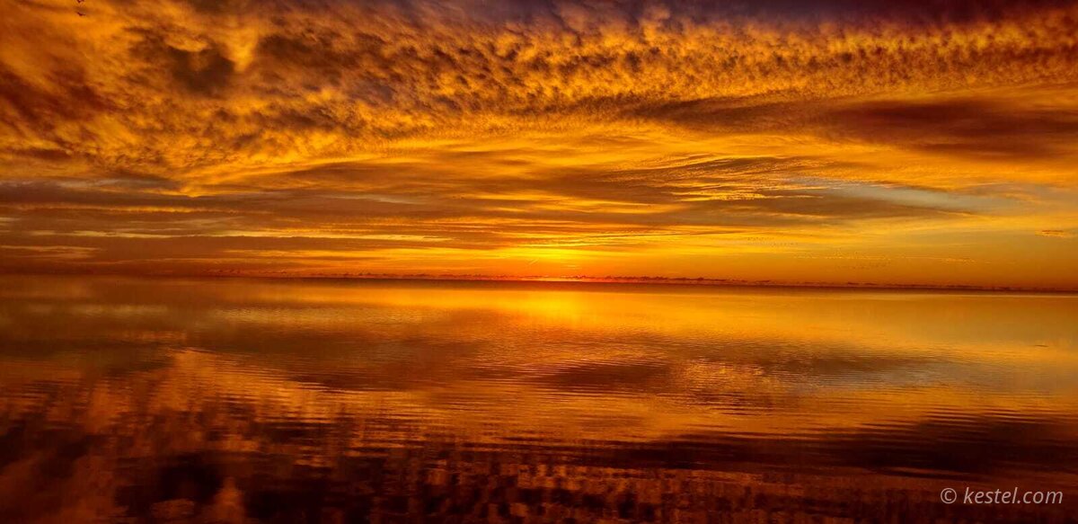 Blazing orange sunrise over open water