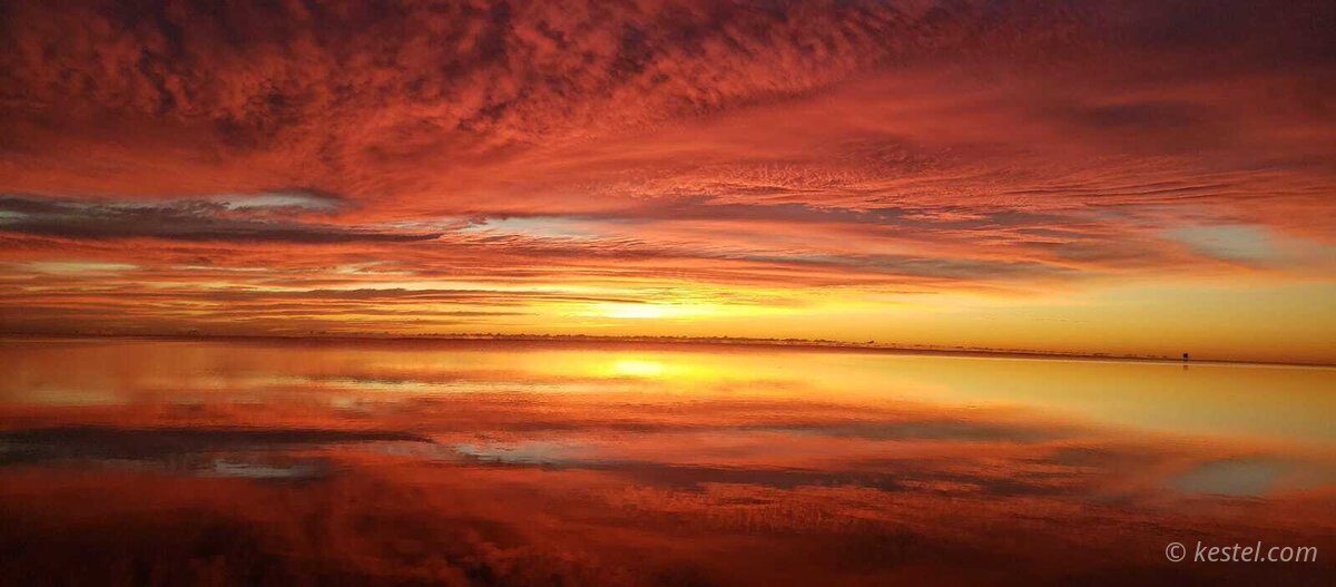 Deep red sunrise over open water