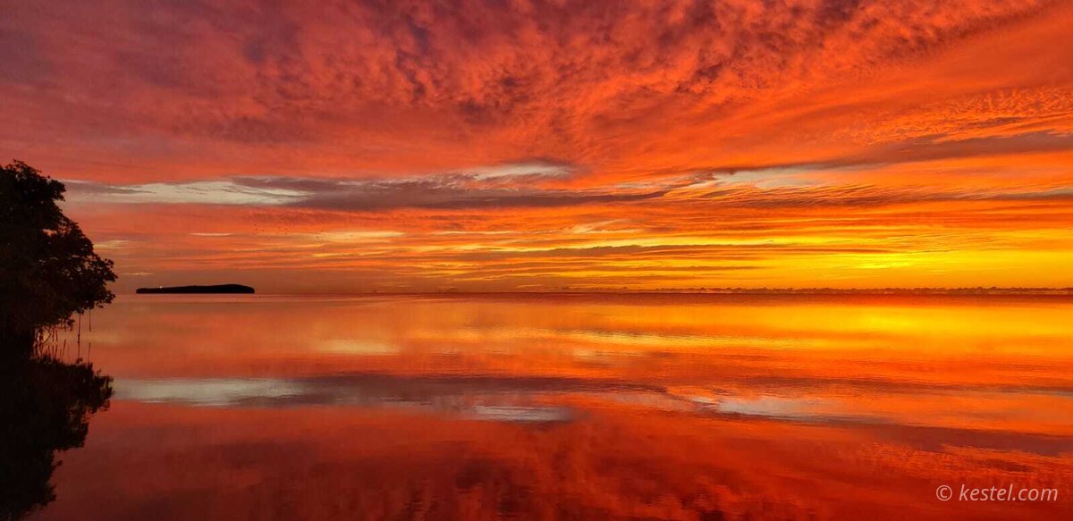Scarlet horizon at sunrise over the water