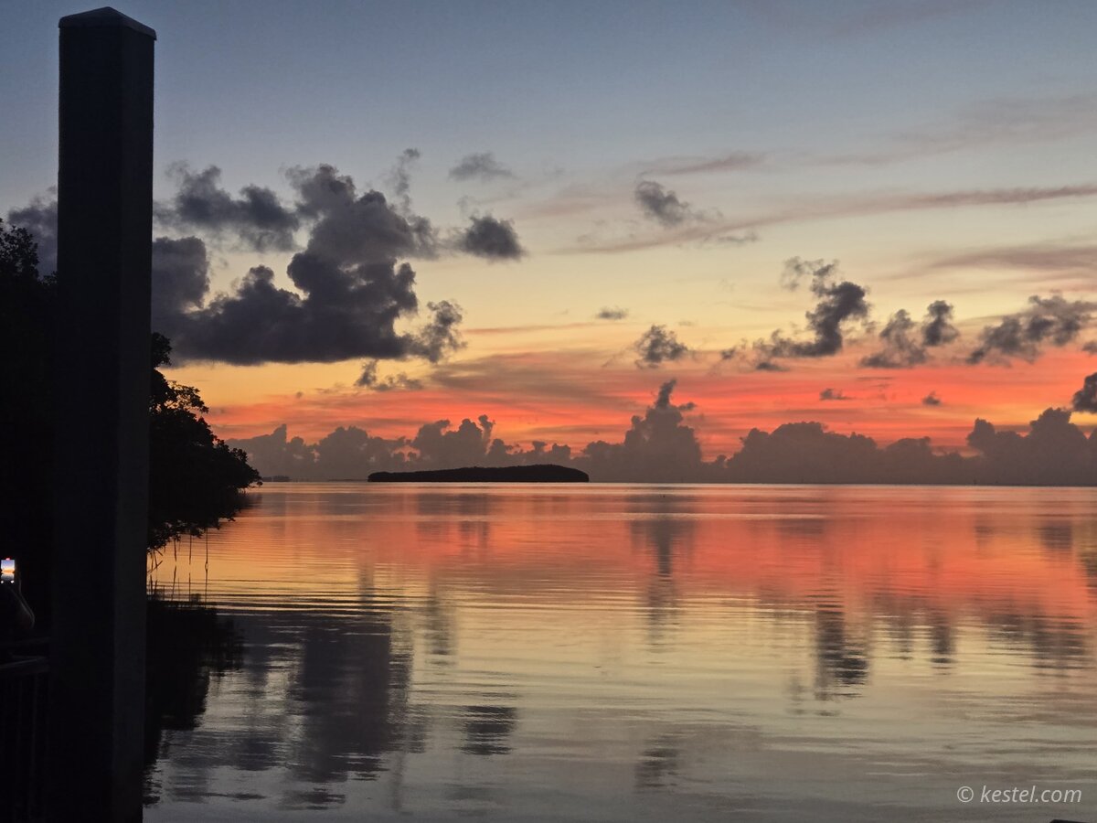 Bay at sunset with island silhouette and water reflection