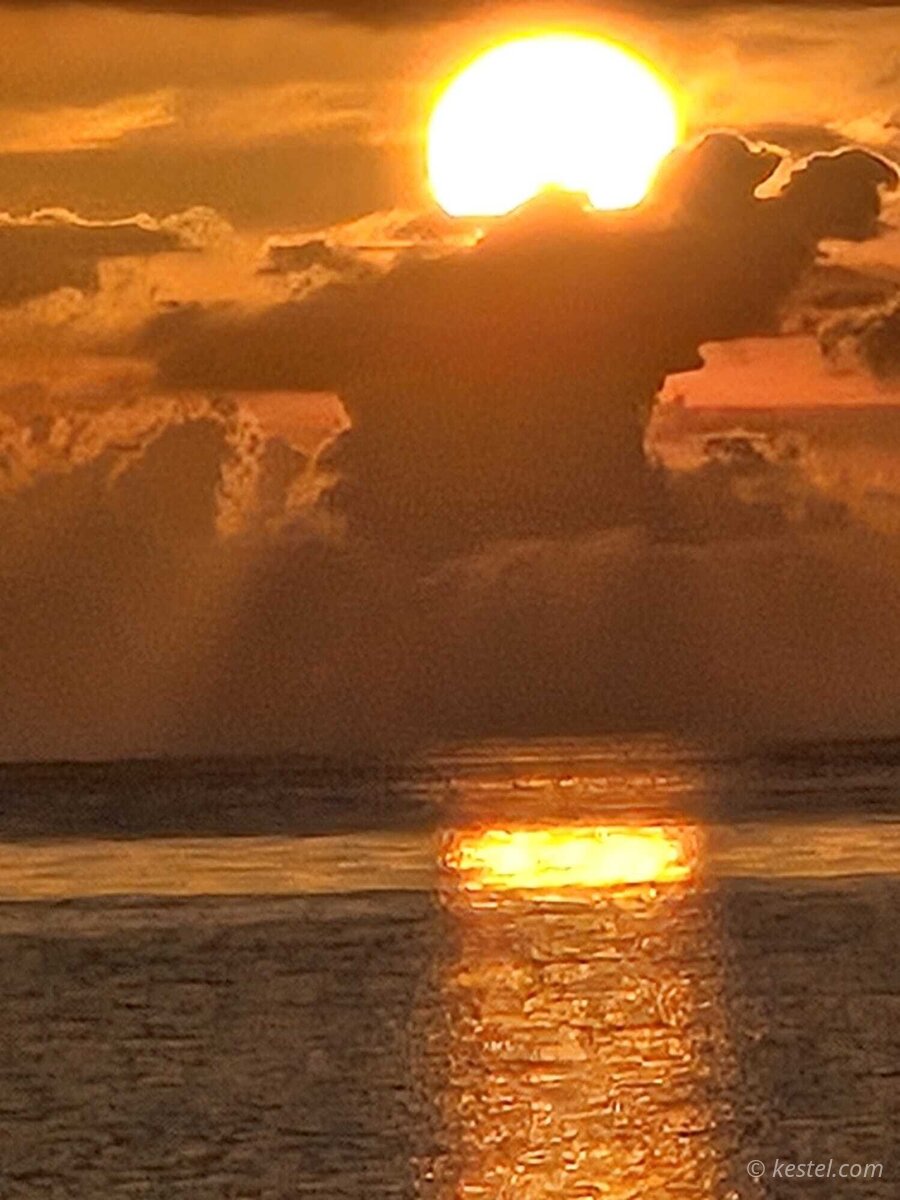 Sun breaking through storm clouds at sunset