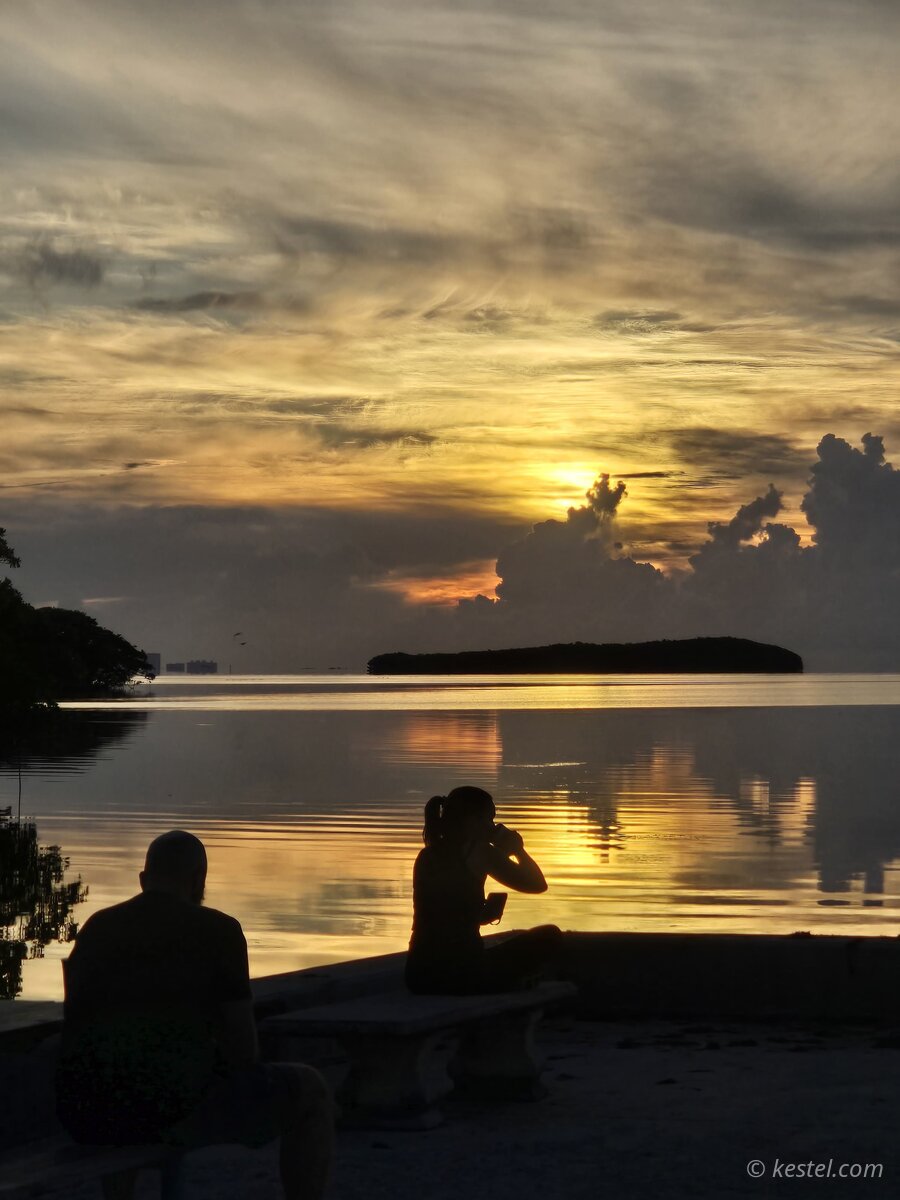 Couple silhouetted against a bay sunset