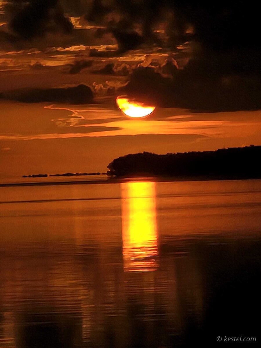 Crescent sun with golden reflection at Virginia Key